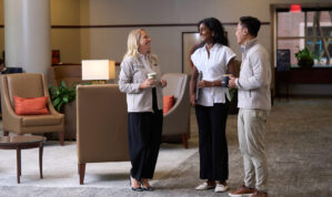 three executives talking in a lobby