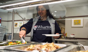 person reaching for food in a buffet line